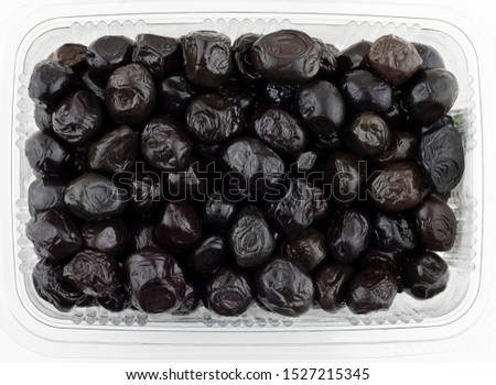 Pack of black olives. Top view Mediterannean cousine ingredient. Bowl of black olives isolated on white backgound.  Royalty-Free Stock Photo #1527215345