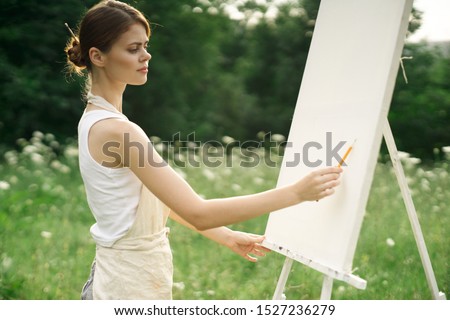 young woman paints a picture a young easel