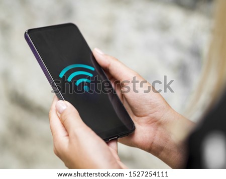 Close-up phone in hands with wifi symbol Royalty-Free Stock Photo #1527254111