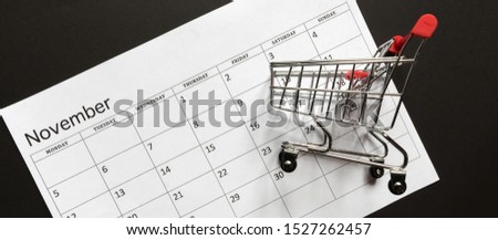Concept image of a calendar and a wheelbarrow for shopping, black friday november season of discounts and sales promotion banner flat lay
