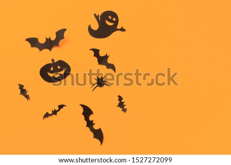 Halloween paper decorations on orange background. Halloween concept. Flat lay, top view, copy space