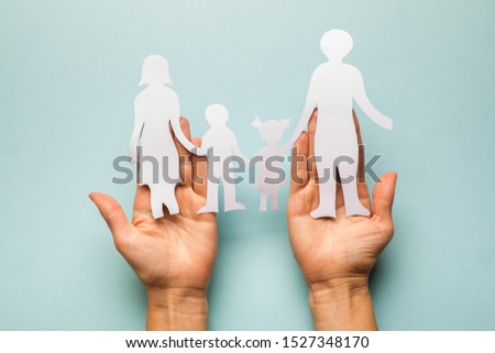 Paper family in hand isolated on blue background