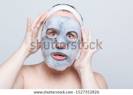 A woman with a foaming mask on her face.