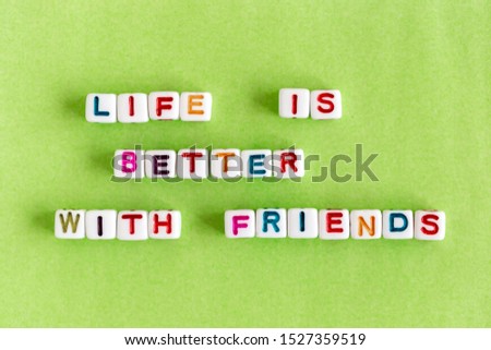 Quote "Life is better with friends" made out of colorful beads