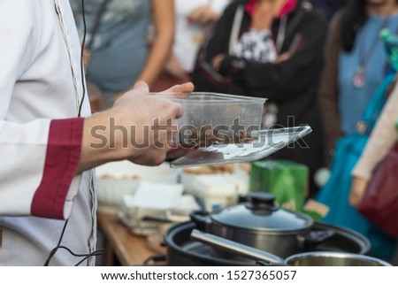 Preparing crickets in a pan for eating at a demonstration event