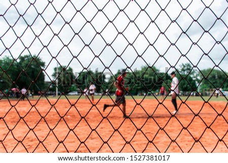 Picture of the softball field being played  That was taken through the net.