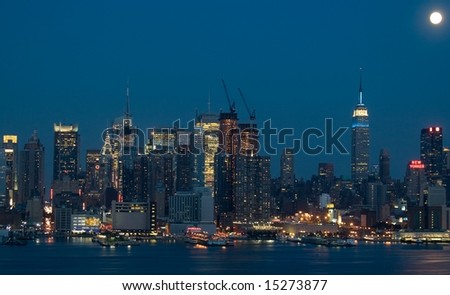 Midtown Manhattan in the early evening with the moon above the city.