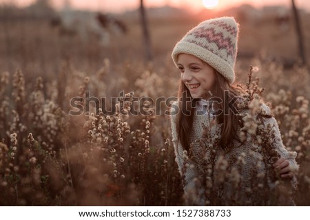 Adorable little girl outdoors on nature in the autumn field