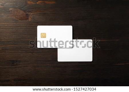 Photo of two blank bank cards on wooden background. Photo of white credit cards. Flat lay.