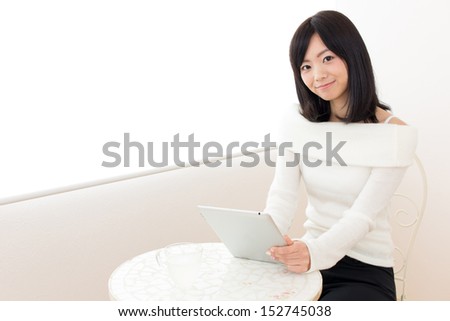 young beautiful asian woman using tablet computer in the cafe