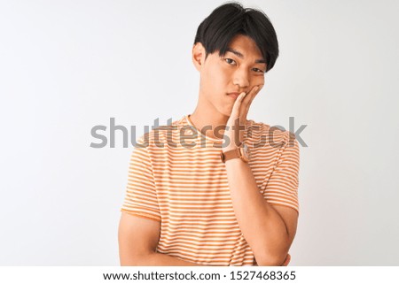 Young chinese man wearing casual striped t-shirt standing over isolated white background thinking looking tired and bored with depression problems with crossed arms.