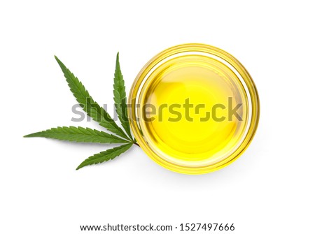 Bowl with hemp oil and leaf on white background, top view Royalty-Free Stock Photo #1527497666