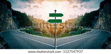 Concept of a blank cross road sign with light behind it. Intended for you to write your own text. Example: Various important choices or to illustrate the decisions you want to present Royalty-Free Stock Photo #1527547937