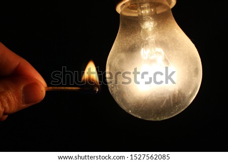 Matchstick and incandescent lamp in the dark