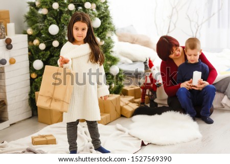 a little christmas girl opens a christmas gift and is surprised