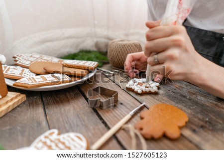 Christmas homemade gingerbread cookies on wooden table. Icing of Christmas bakery. closeup, copy space. Blank biscuit gingerbread house, ready to decorate.
