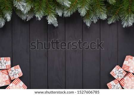 New year or Christmas black wooden background with fir tree and decor. Top view with copy space.