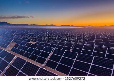 Aerial view of hundreds solar energy  panels rows along the dry lands at Atacama Desert, Chile. Huge Photovoltaic PV Plant in the middle of the desert from an aerial drone point of view during sunset Royalty-Free Stock Photo #1527609272