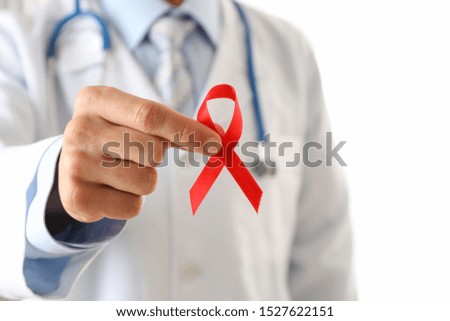 Doctor holds a red ribbon, close up and space for text