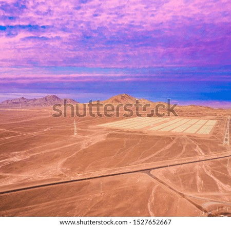 Aerial view of a huge Solar Energy Farm along the dry sand lands at Atacama Desert, Chile. Infinite Photovoltaic PV Plant in the middle of the desert from an aerial drone point of view during sunset