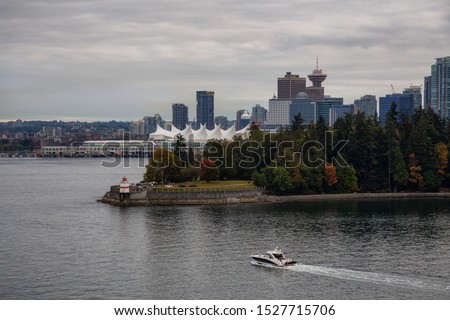 Brockton Point Lighthouse in Stanley Park, with Vancouver Downtown, BC, Canada, in the background. Taken during a cloudy summer evening from a Boat.