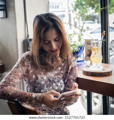 Asian woman using smart phone at coffee shop, lifestyle concept.