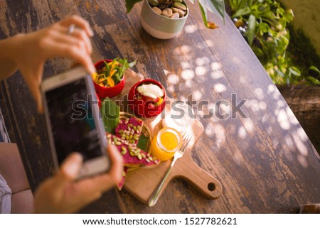 Woman hands takes photography of food on table with phone for internet blog. Smartphone photo for vegetarian, healthy and organic social networks post