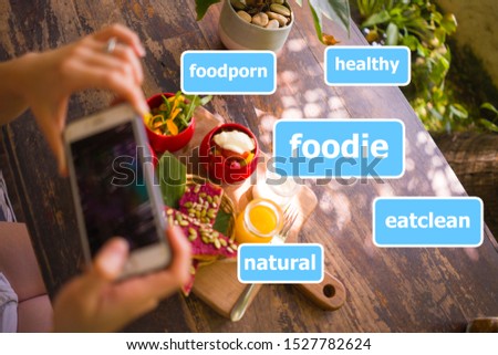Woman hands takes photo of food on table with phone for internet blog. Smartphone pic for vegetarian, healthy and organic social networks post composed with media app hashtags