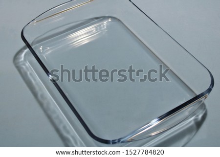 Glass pan for frying food on a gray background.