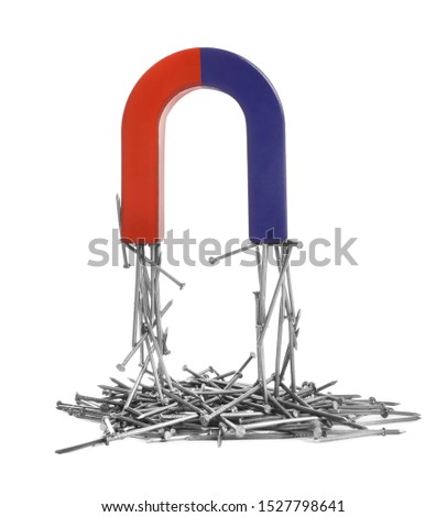 Horseshoe magnet attracting nails on white background