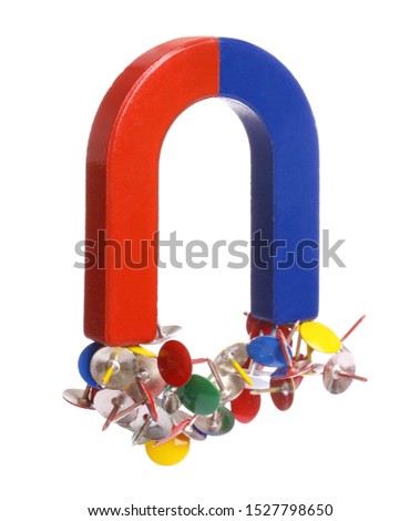 Horseshoe magnet attracting colorful drawing pins on white background