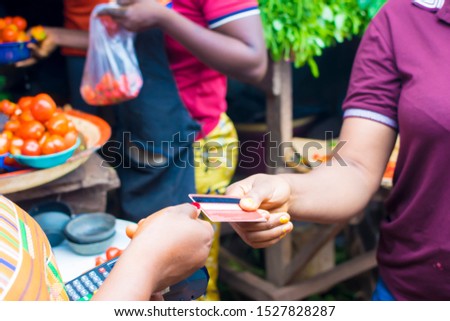 Young African trader holding a point of sale machine with a credit card. Woman making payment with Bank card  