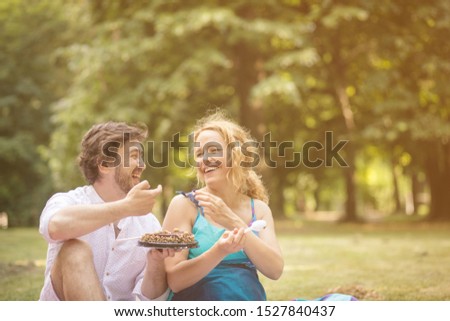 I am happy with you. Couple in a meadow with a birthday cake.