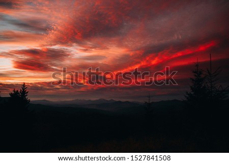 Magical sunset in the mountains. The sky is covered with clouds of red