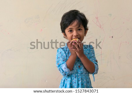 Indian little girl enjoying apple with fun