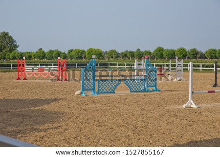 Horse agility track with jump obstacles for equestrian sports . Image of show jumping poles on the training field. Wooden barriers for jumping horses as a background. 
