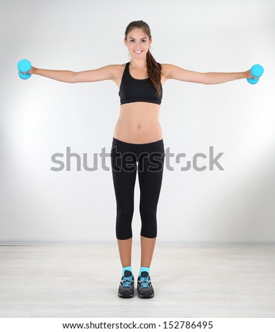 Beautiful young girl doing exercises at home