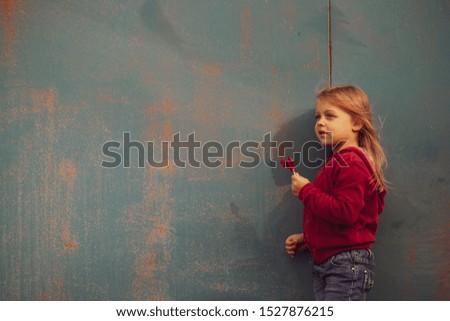 Baby with red candy on a blue background.