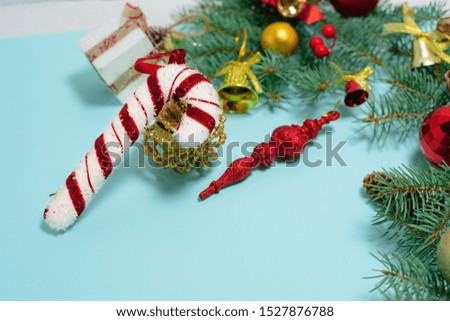 Christmas composition of Christmas toys, candy and spruce branches on a blue background. space for text.