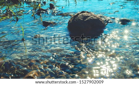 Mountain Stream with Big Boulder, Green Plants, Pebble and Bright Sunny Sparkles on the Surface. Summer Afternoon. Royalty-Free Stock Photo #1527902009