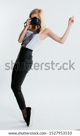 Portrait of beautiful woman with camera having fun at the white background