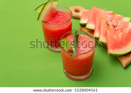 Fresh juice of watermelon, smoothie, cocktail. Sweet summer dessert, slices on wooden cutting board. Healthy food concept, green background, copy space, close up