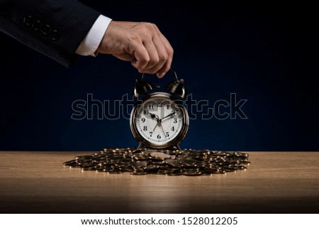 Clock and pile of coins with businessman