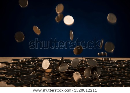 lot of coins fall on wooden desk