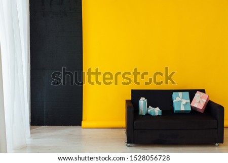 office sofa with gifts in the interior of the room with a yellow background