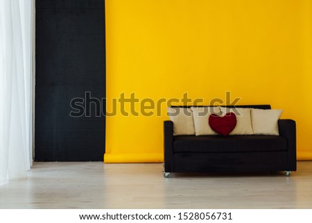 black office sofa in the interior of the room with a yellow background