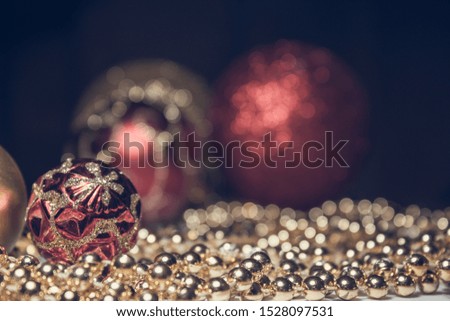 Christmas toys gold and red with gold beads on the table. Red ball with gold pattern. New year's footage with the Christmas tree decorations in warm colors