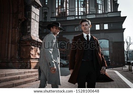 Two fashion men on urban background in stylish casual and classic clothes with trendy hairstyle. Handsome bearded man model portrait on city Royalty-Free Stock Photo #1528100648