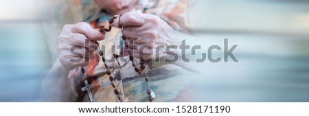 Old woman praying the rosary; panoramic banner