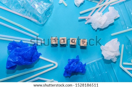Word STOP written with wooden letter, surrounded with variety pieces of plastic to represent pollution concept Royalty-Free Stock Photo #1528186511